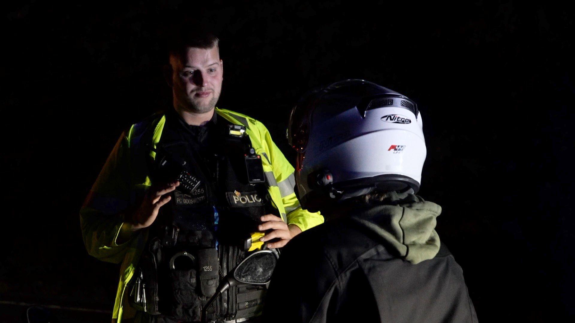 A police officer talks to a young man