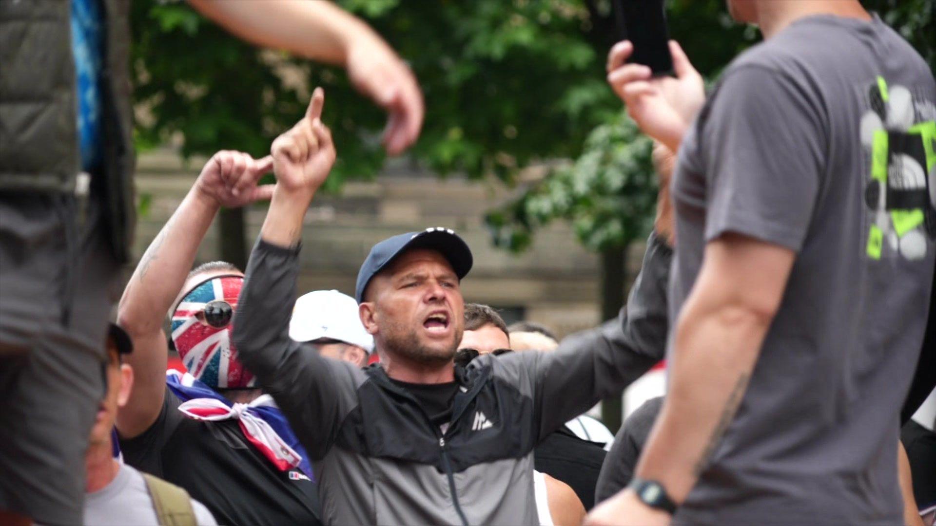 A man in a baseball cap with his arms in the air