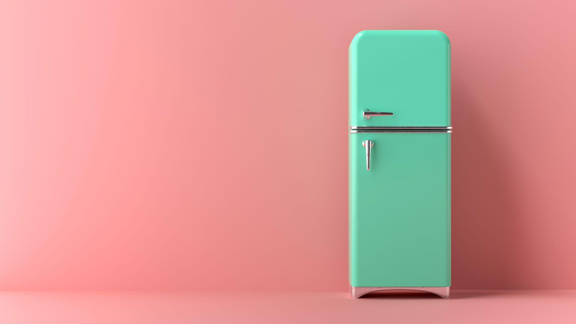 A green fridge freezer (1960s style), on the right side of the picture, with a rose-pink background