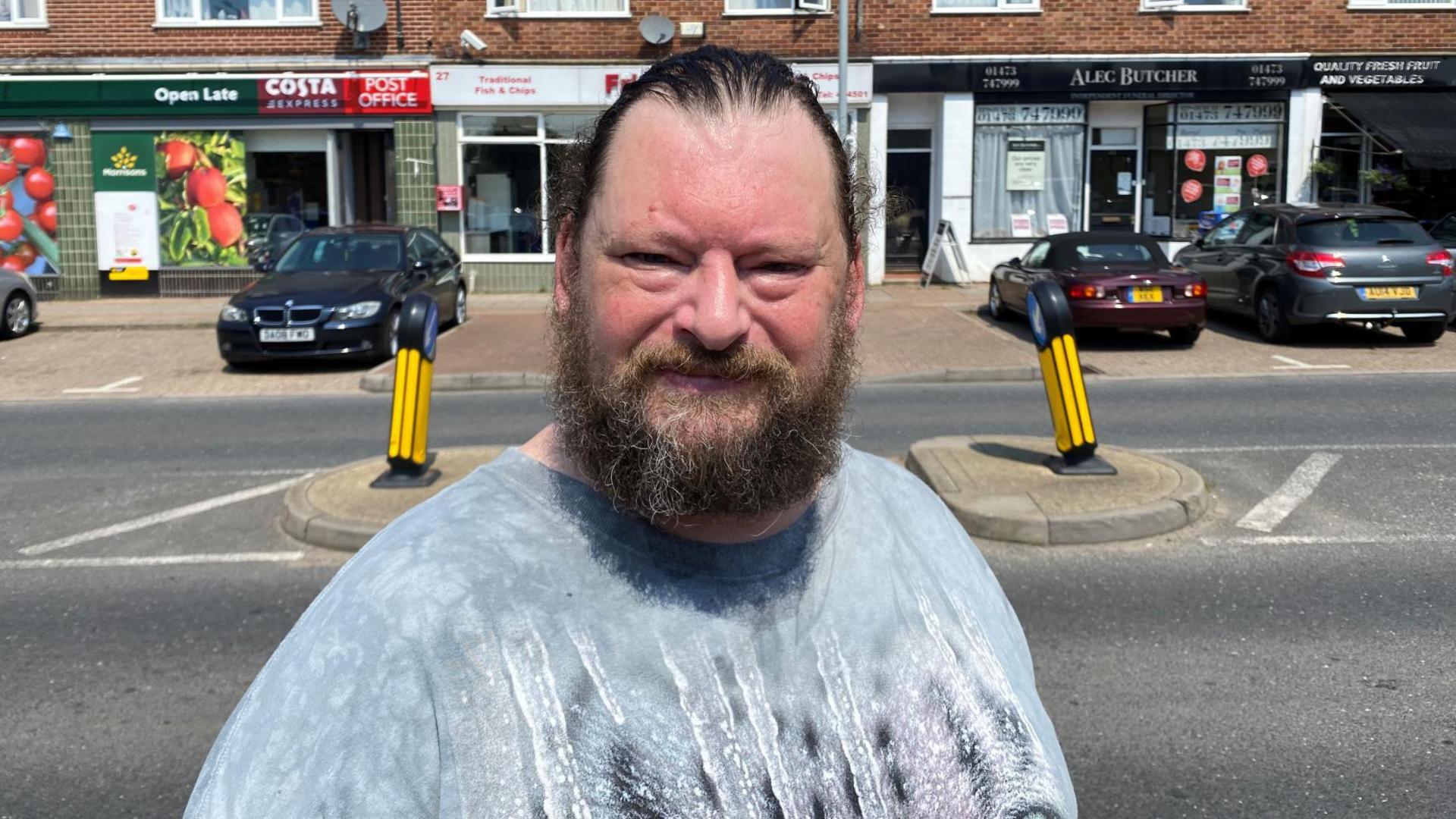 Man with a beard looks to camera