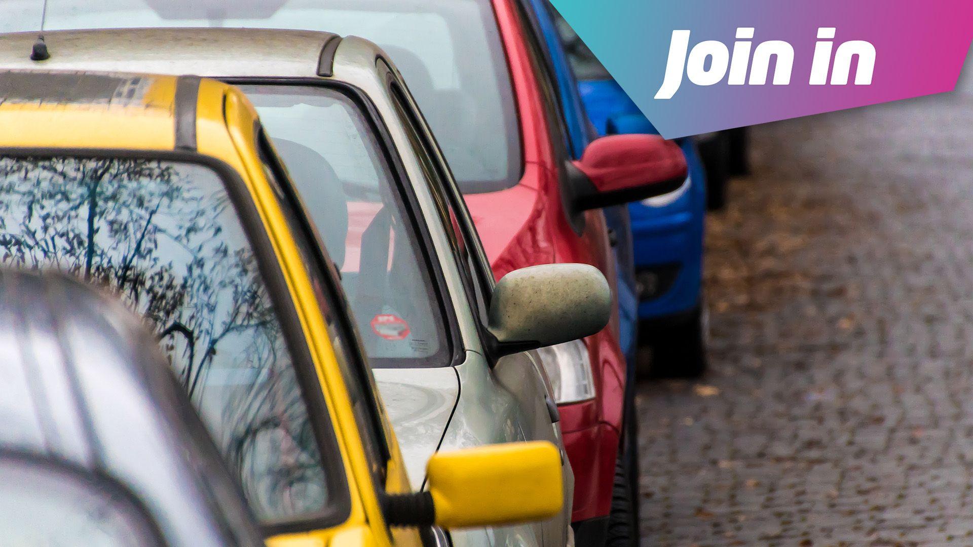 A line of cars in different colours. Yellow, then silver, then red and blue behind that. They are parked on the side of the road. 