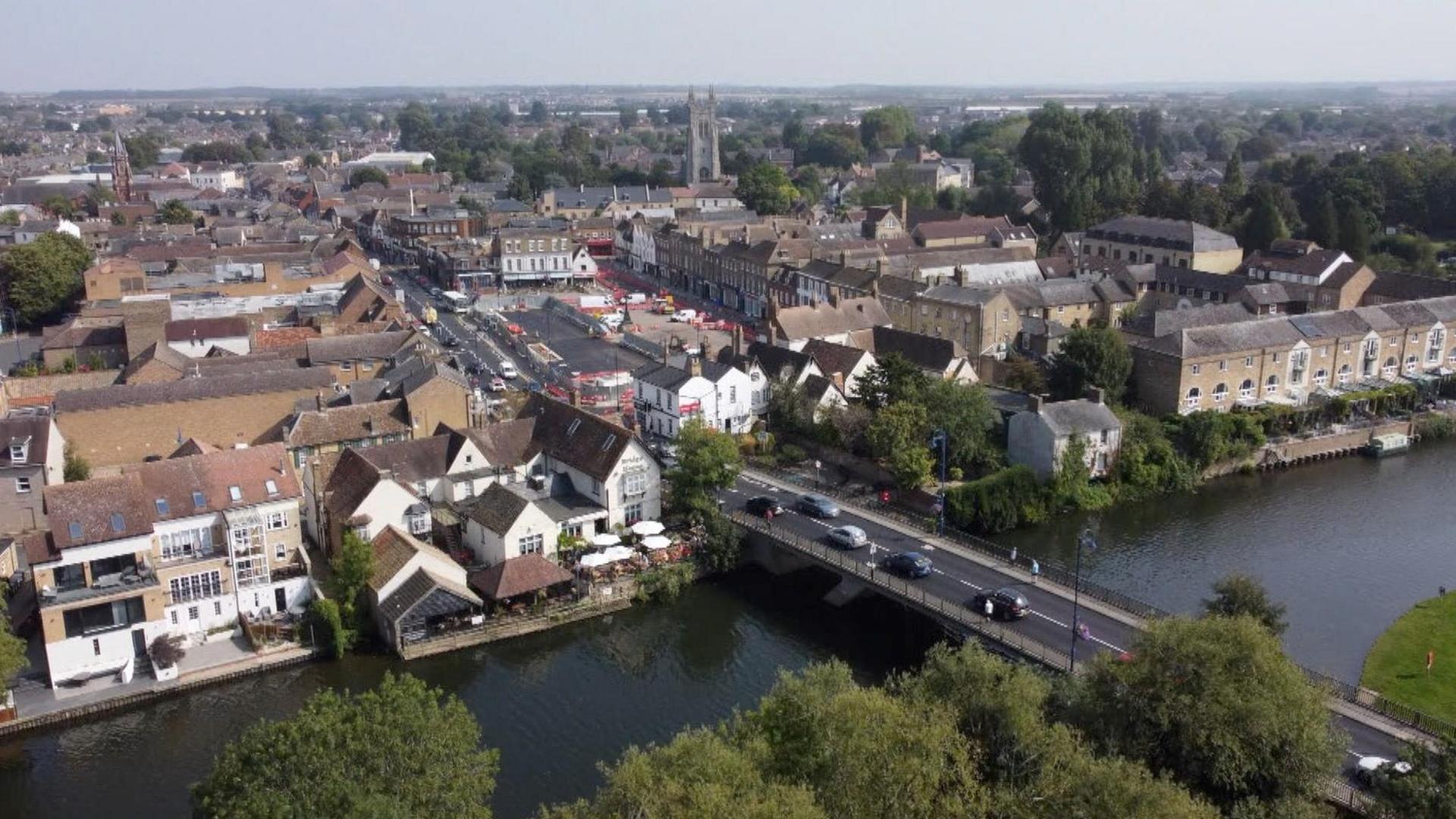 An aerial view of St Neots, showing cars crossing a bridge over a river