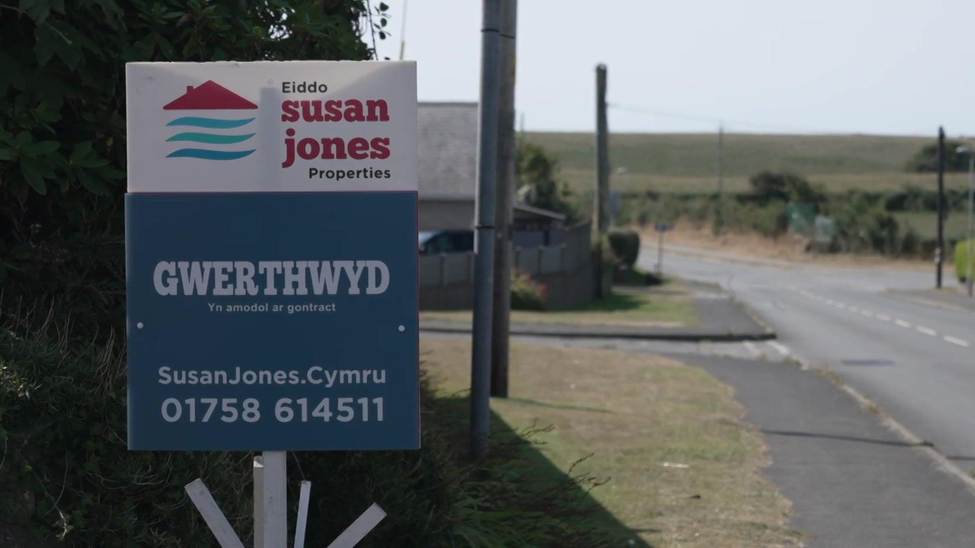 Arwydd 'Gwerthwyd' tu allan i eiddo ar bwys y brif ffordd drwy Forfa Nefyn
