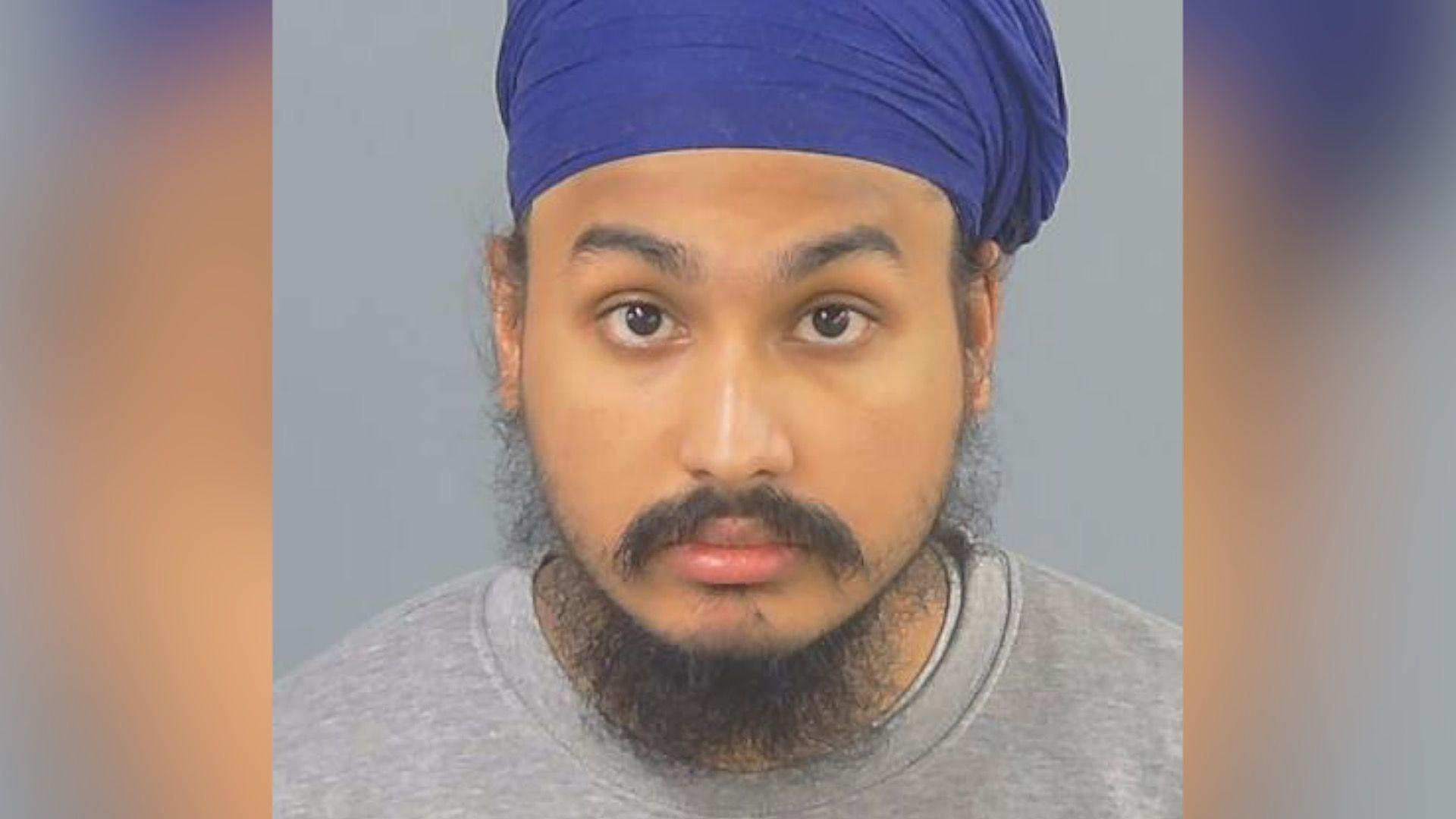 Custody photo of Vickrum Digwa, a man with a beard, a grey jumper and a purple turban looking to the camera.