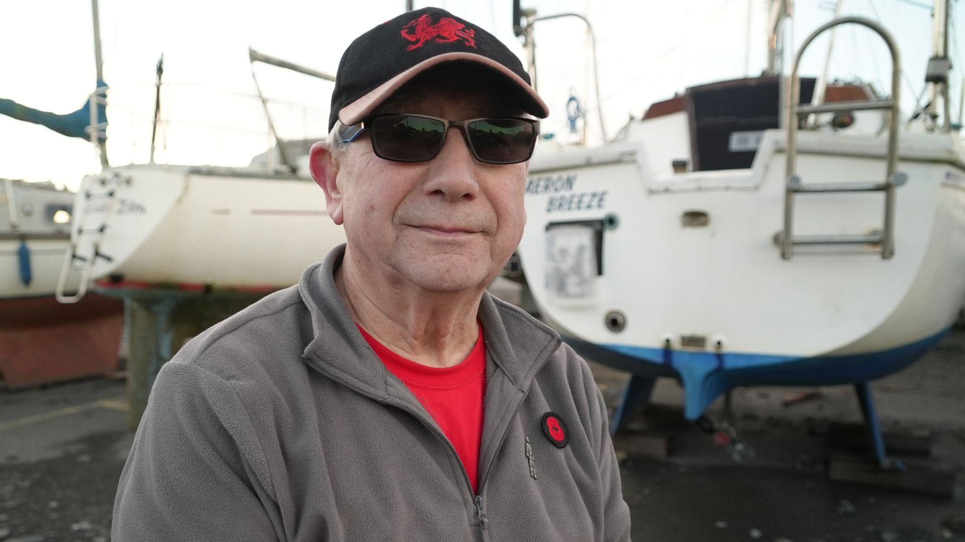 Dai Lewis yn sefyll o flaen ei gwch, yr Aeron Breeze