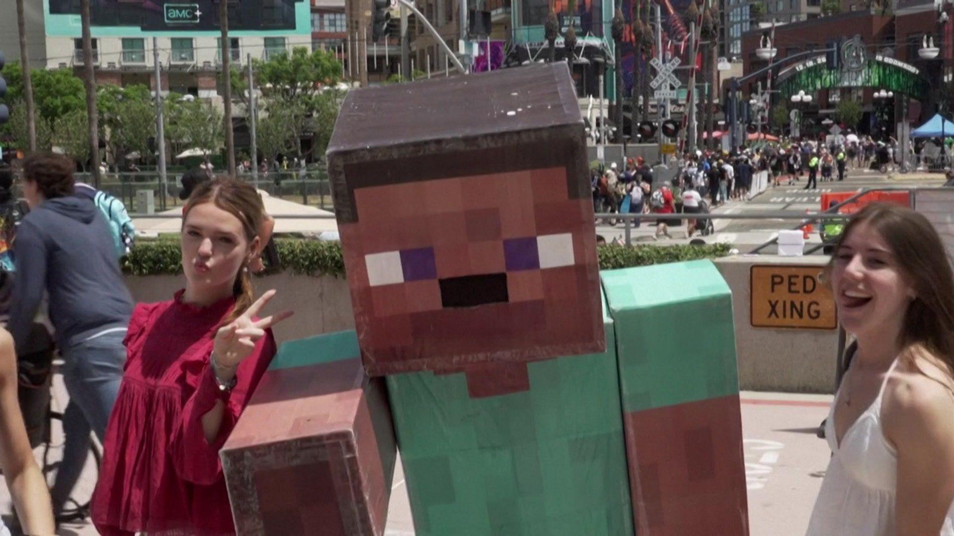 two young women having a photo with someone in a Minecraft Steve outfit