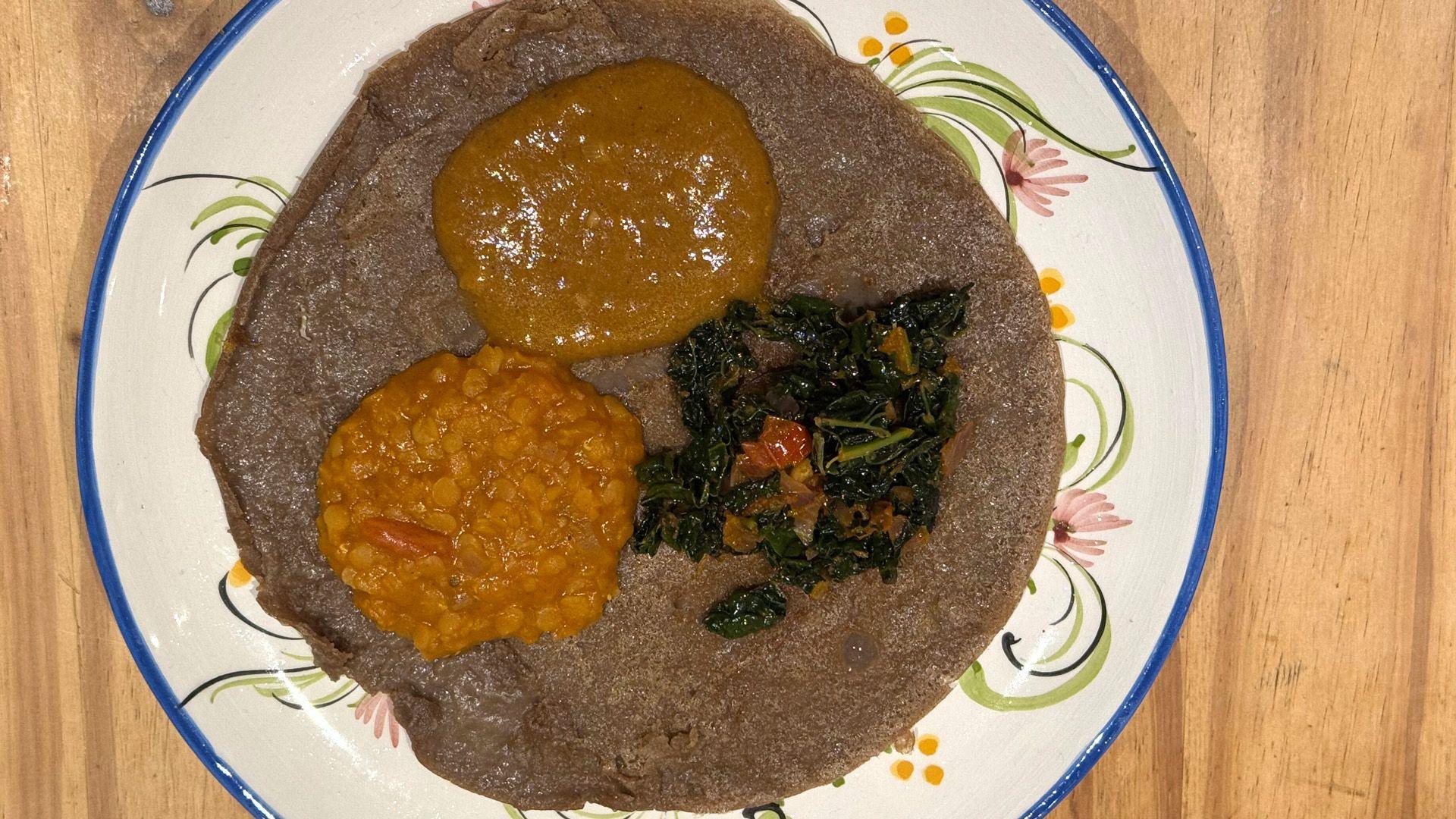 Izzie Cox's injera topped with classic Ethiopian dishes shiro wat (a roasted gram flour-based stew), misir wot (red lentil stew) and gomen wat (spiced greens) 