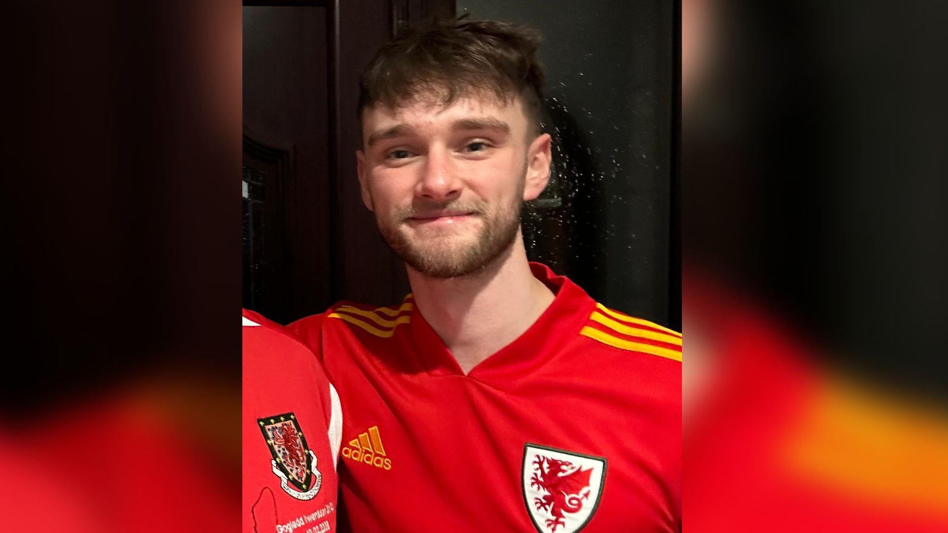 Llun o Kieran Thomas Hughes mewn crys Cymru