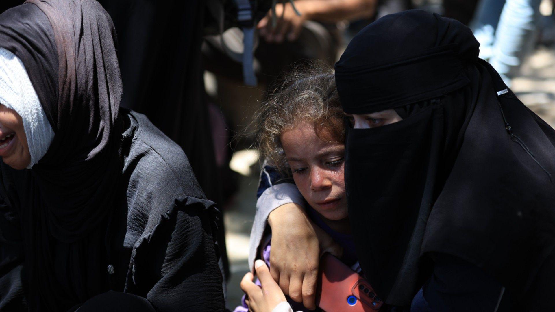 Women and a child wait for aid in Gaza on 20th July 2025
