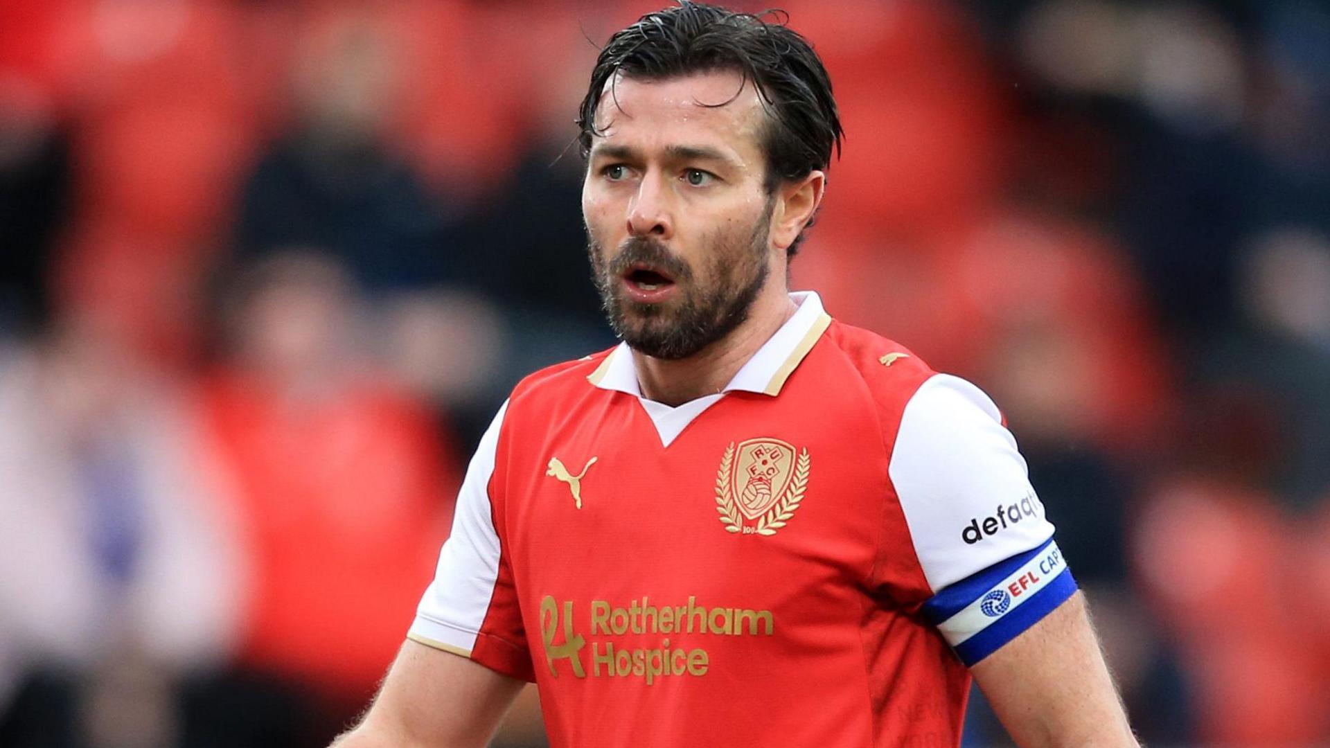 Joe Rafferty, with a captain's armband on his left arm, playing for Rotherham