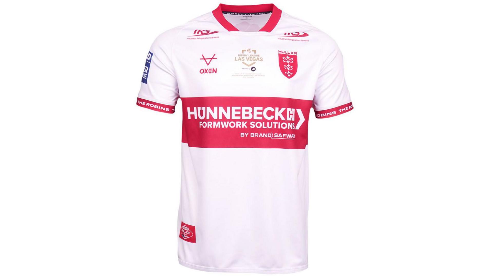 A red and white rugby league shirt on a white background. The shirt is mostly white with red trim around the collar and sleeves and a large red band around the centre. It features several sponsors' logos, a red Hull Kingston Rovers logo and a gold logo which says "Rugby League Las Vegas".
