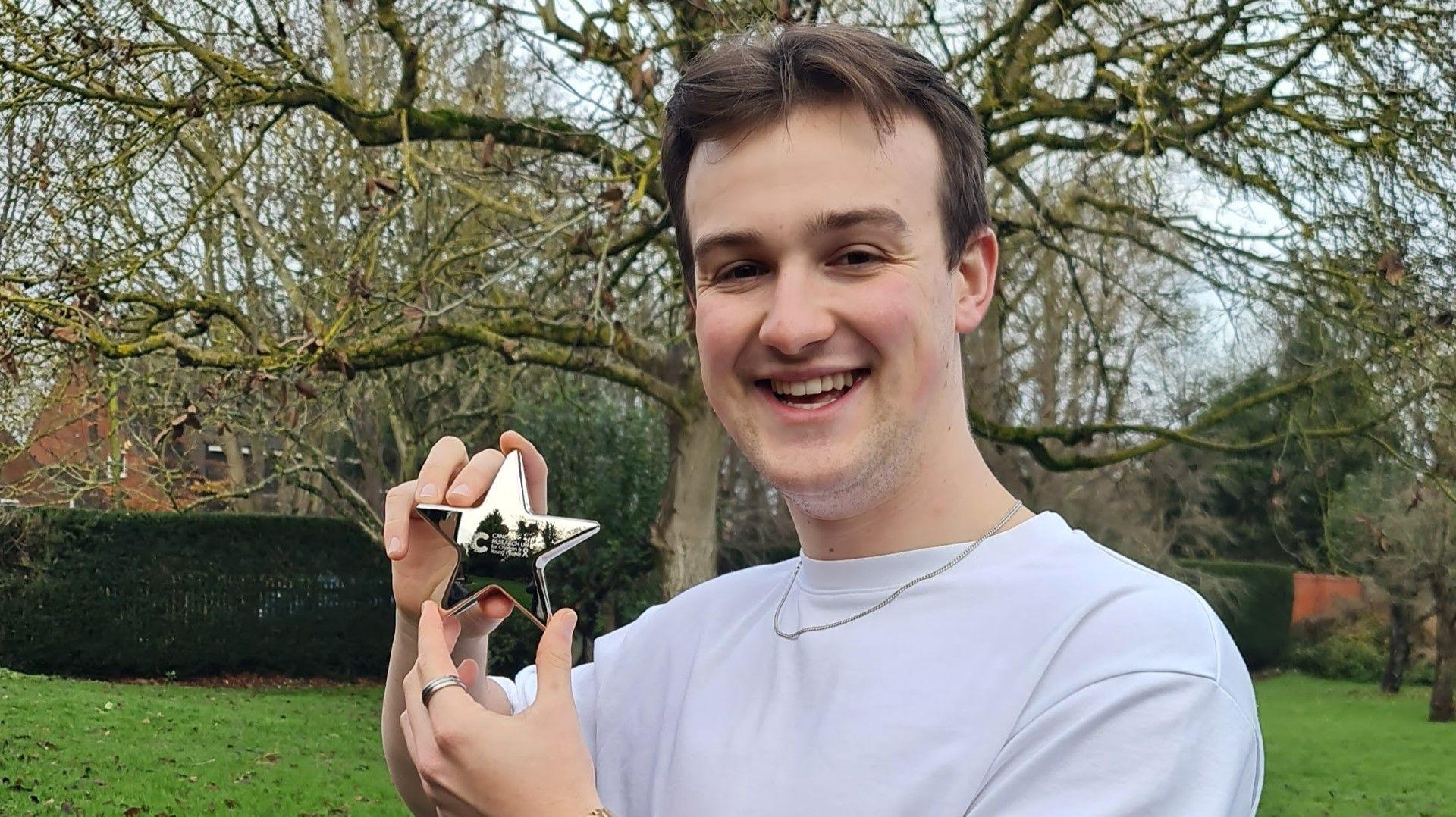 Thomas Ashley holding a Cancer Research UK Star Awards