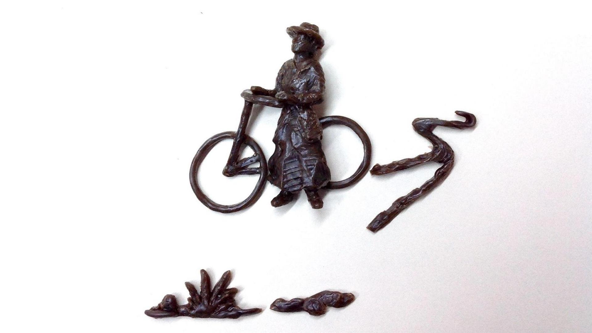 A bronze design of Isabel Cowe and her bicycle