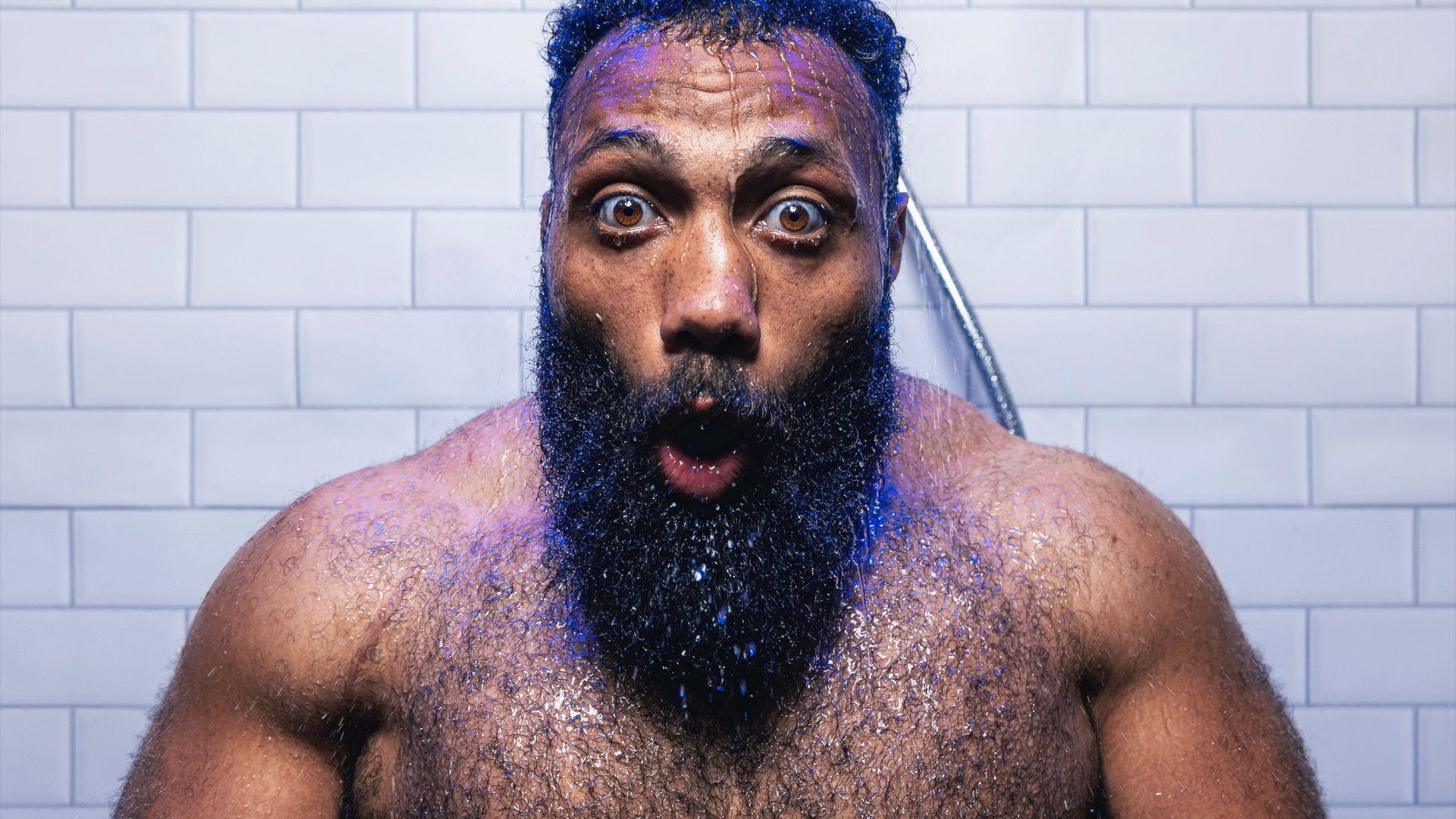 Gloucester Rugby player Jamal Ford-Robinson with facial hair looking shocked into the eye of the camera as he stands under a cold shower