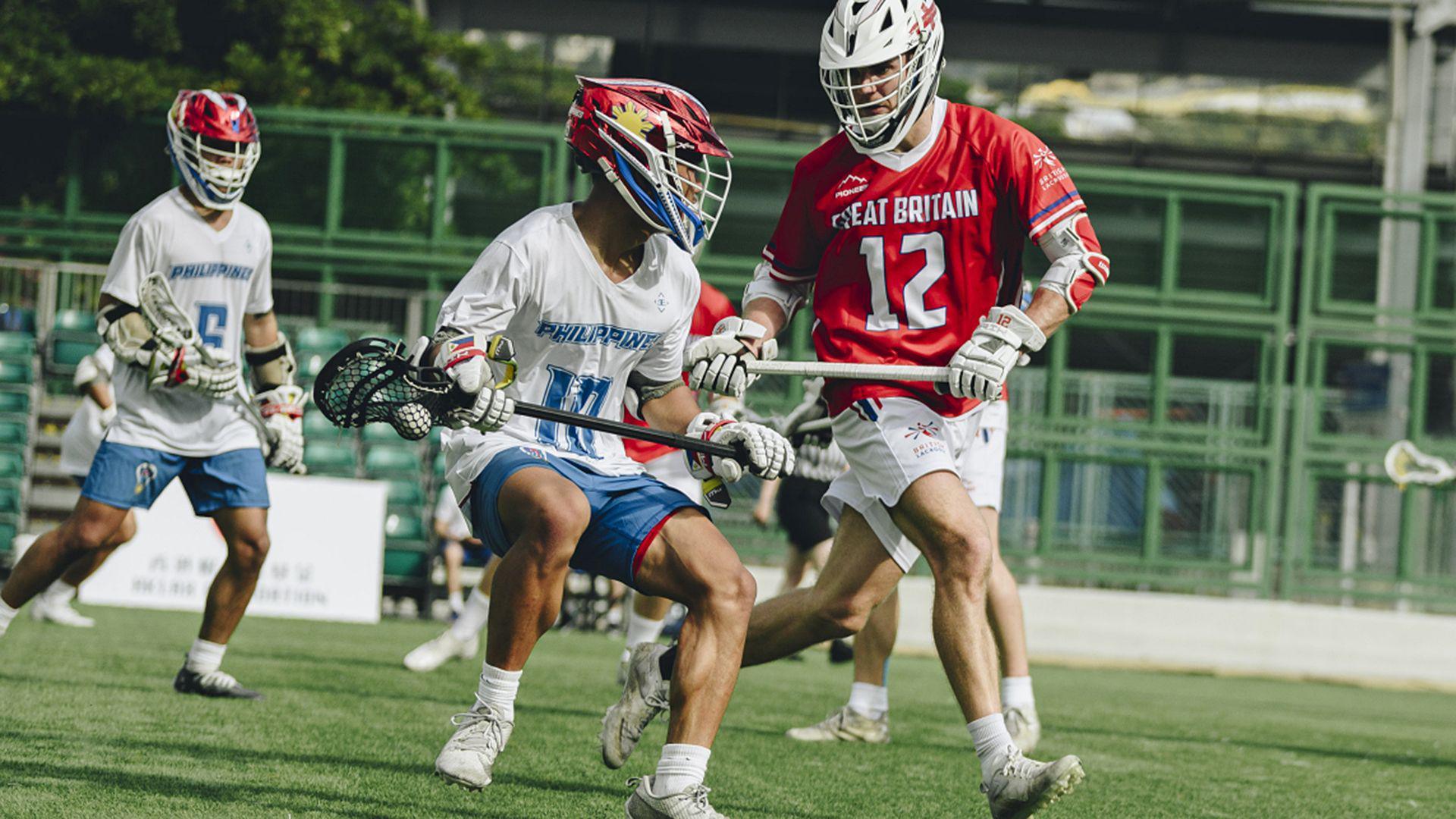 Tommy Kirkland, in a red Great Britain shirt and white shorts, playing against the Philippines in lacrosse 