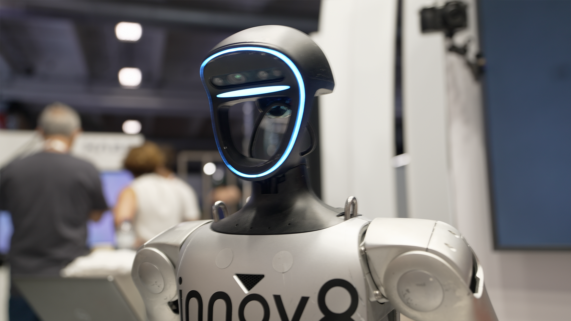 Close up of a humanoid robot with a black head with a blue light around it 