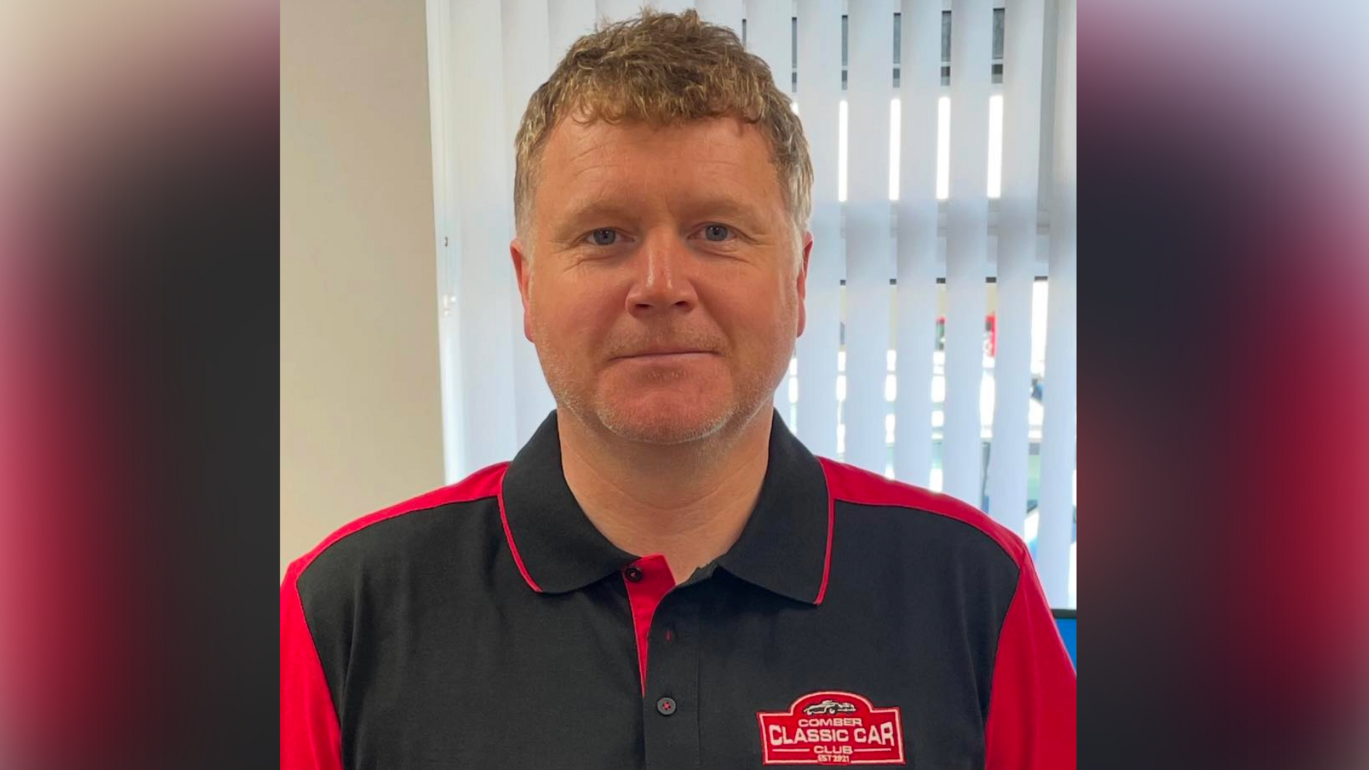 Stephen has short blonde and brown hair, and light coloured facial hair. He is wearing a black polo shirt with red detailing and a red badge which reads 'Comber Classic Car Club'.