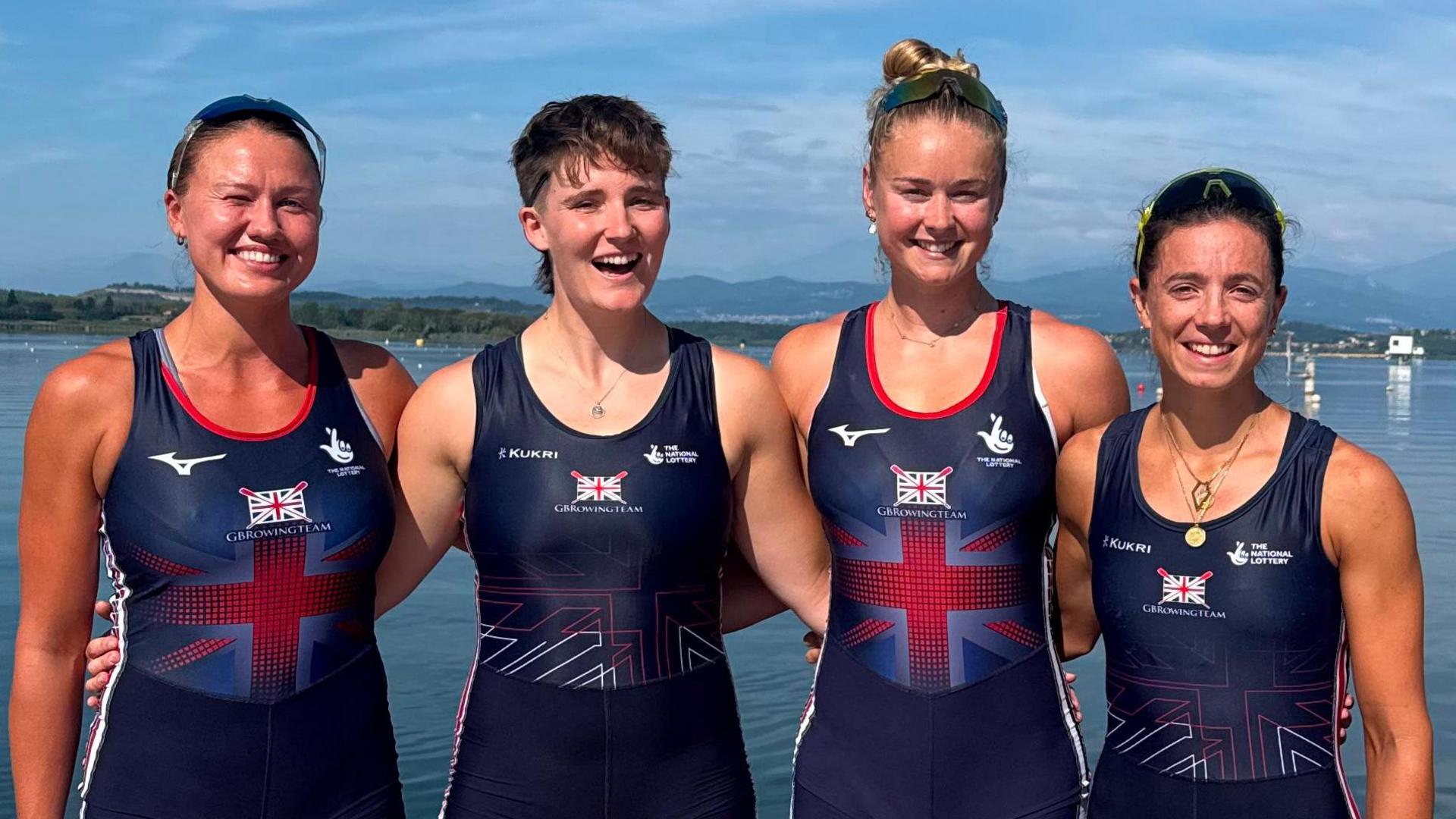 Imogen Grant standing next to a lake with three of her teammates in the women's quadruple sculls.