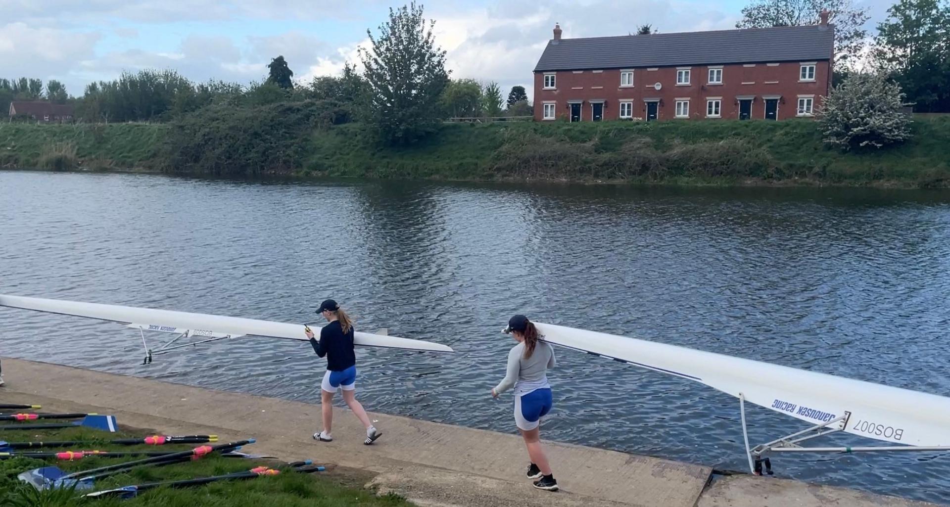 Rowers lifting boats into the river