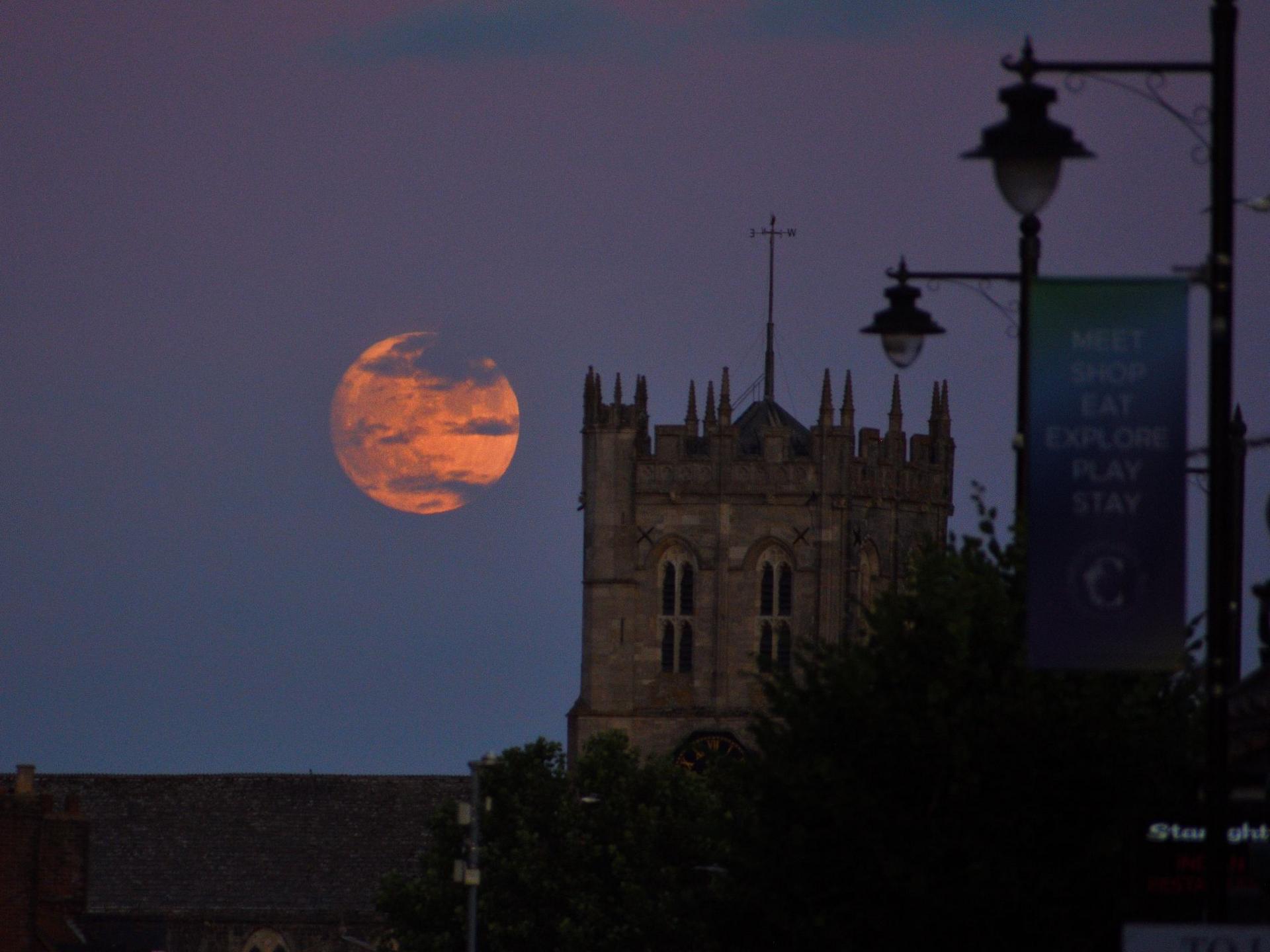 Strawberry Moon rising beside Christchurch Priory