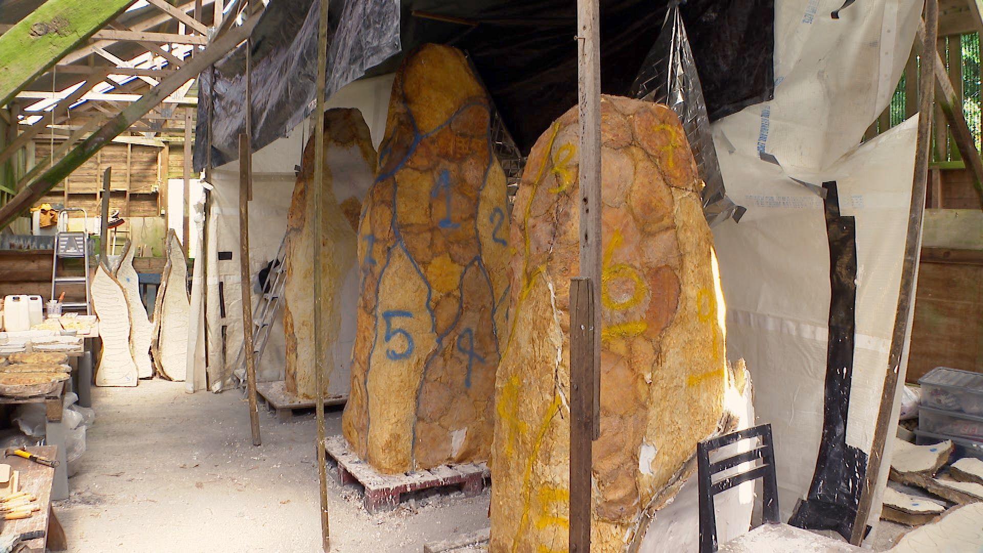 Three tall structures in a shed which will become bronze-covered modern monoliths