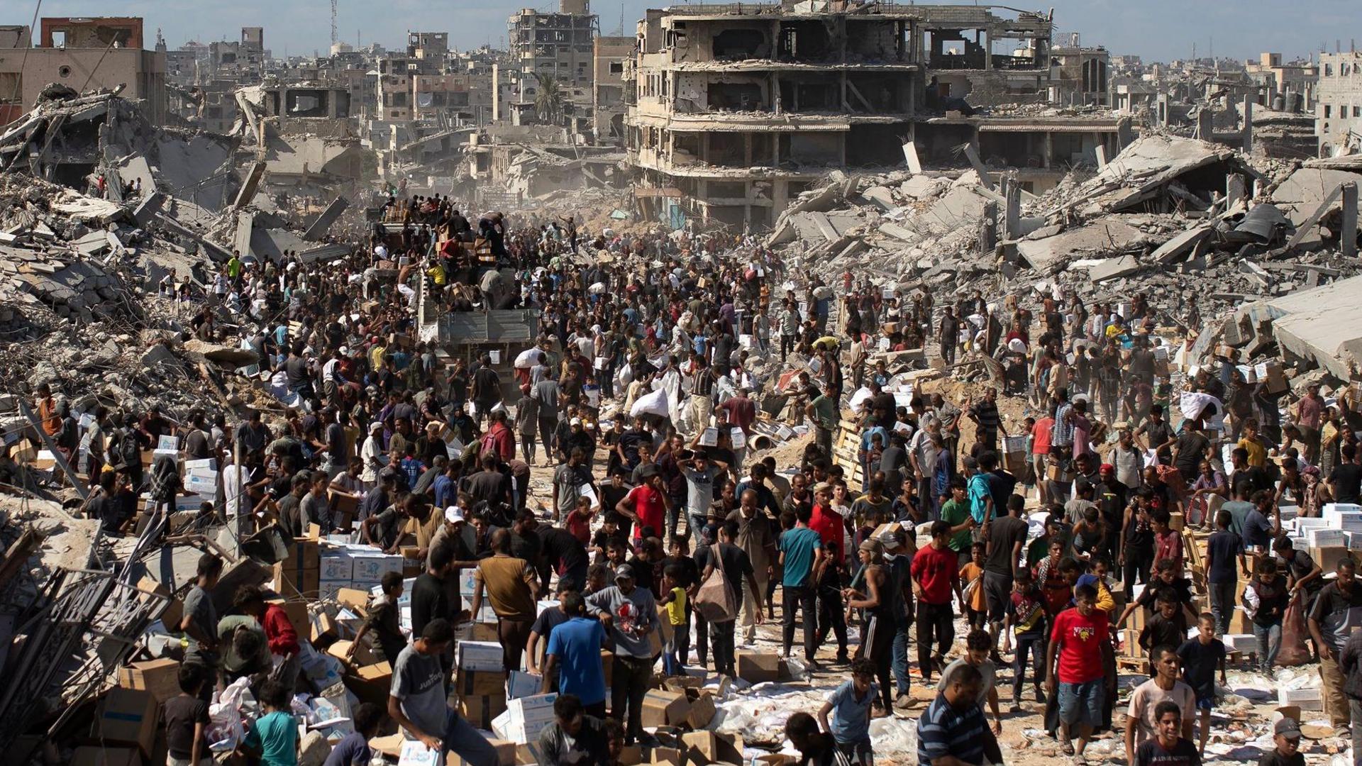 Palestinians take aid supplies from a truck that arrived in Khan Yunis in the southern Gaza Strip on 12 October
