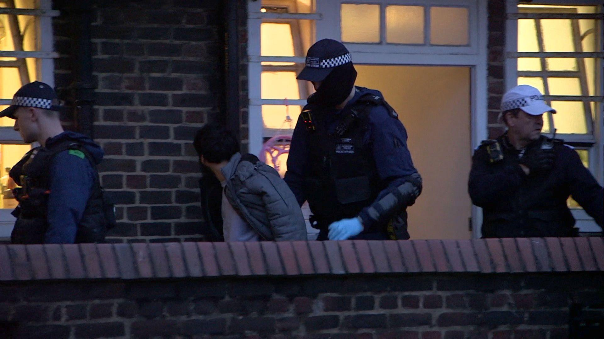 A man is led away by officers