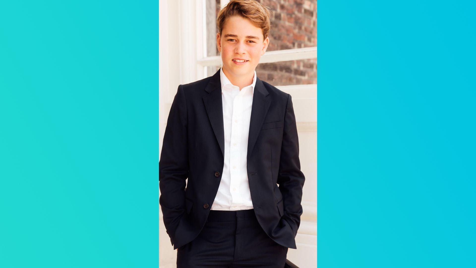 Prince George in a dark suit with open neck shirt.
