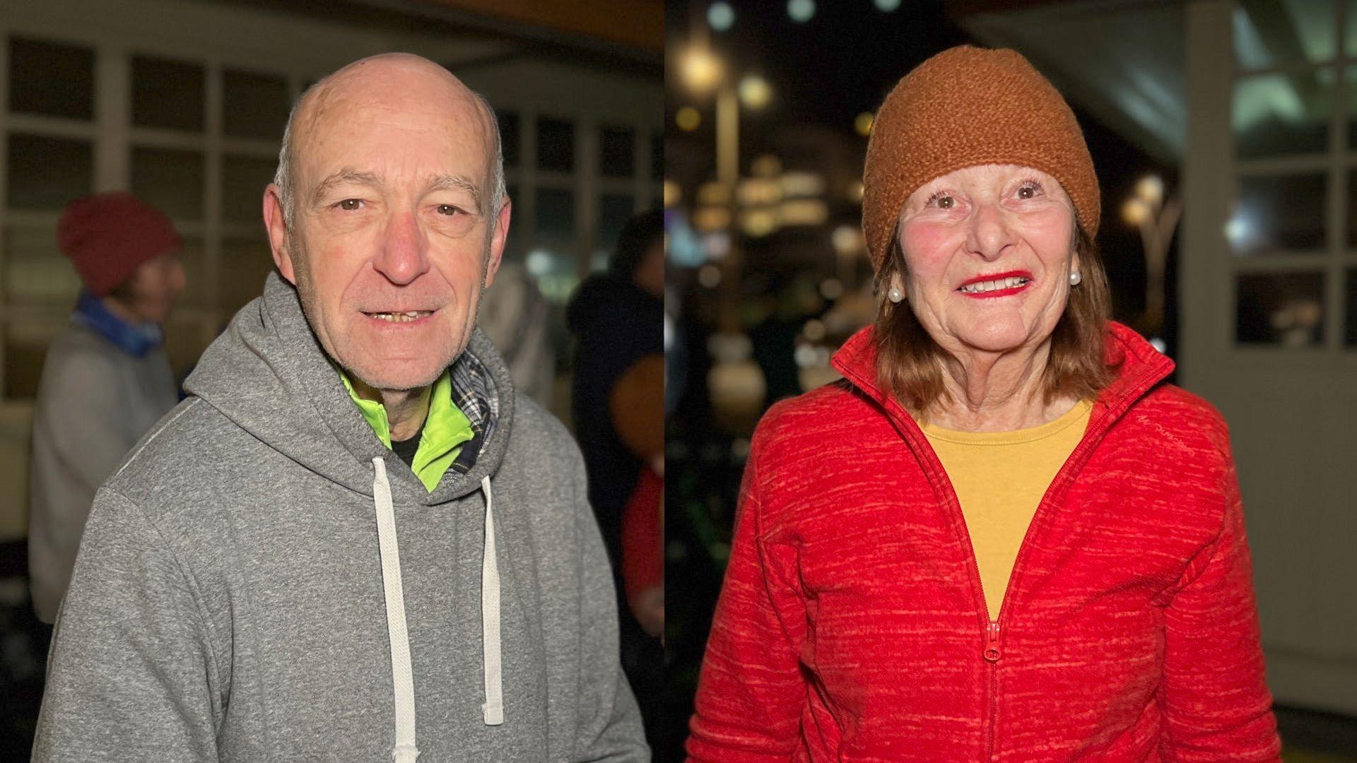 Bernie is wearing a grey hoodie with a high-viz top underneath and has grey hair on the side of his head. Janine is looking at the camera as she wears a red zip-up top with a yellow running shirt underneath. She has  short light brown hair and is wearing a brown knitted hat.