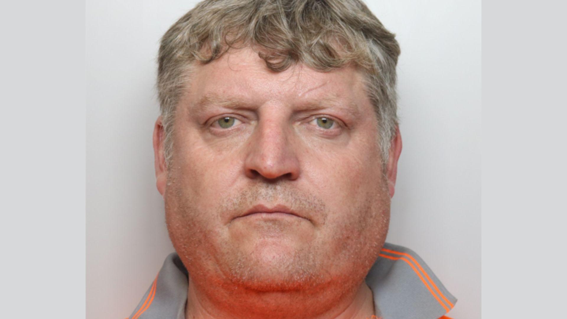 A police mugshot depicts a man facing the camera