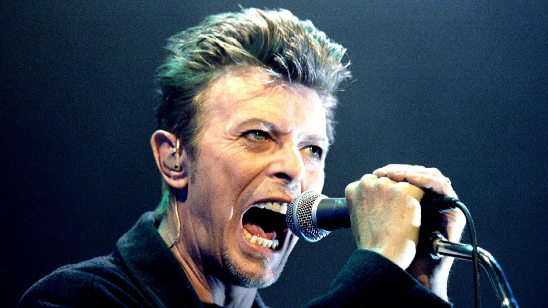 British Pop Star David Bowie screams into the microphone as he performs on stage