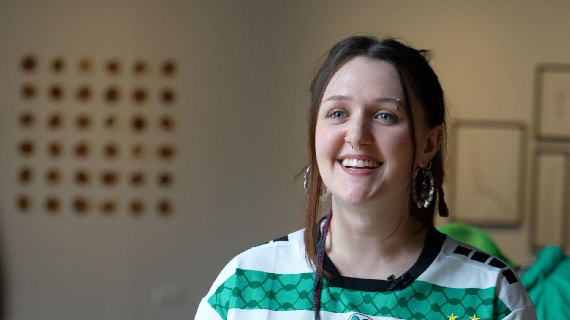 A young woman in a stiped top stares at the camera