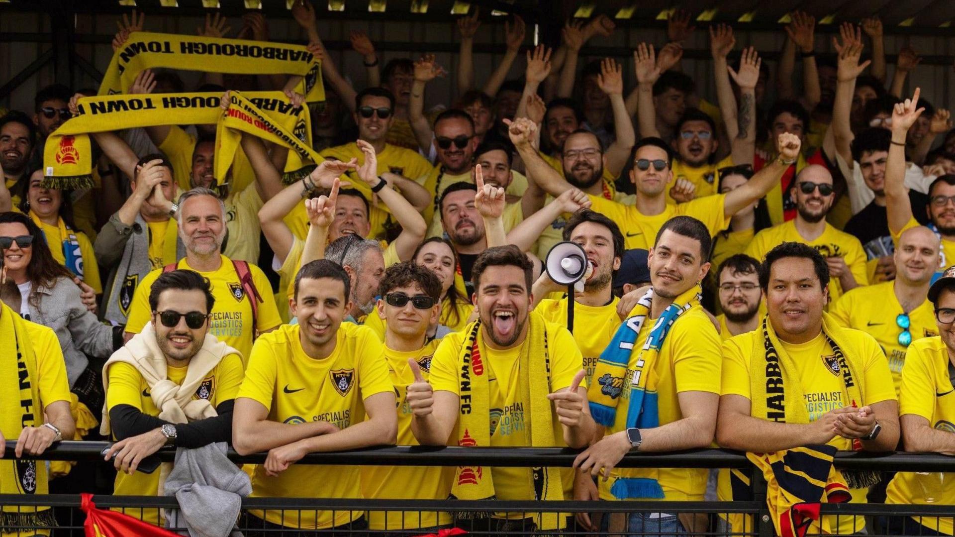 Dozens of Spanish football fans wearing Harborough Town football shirts