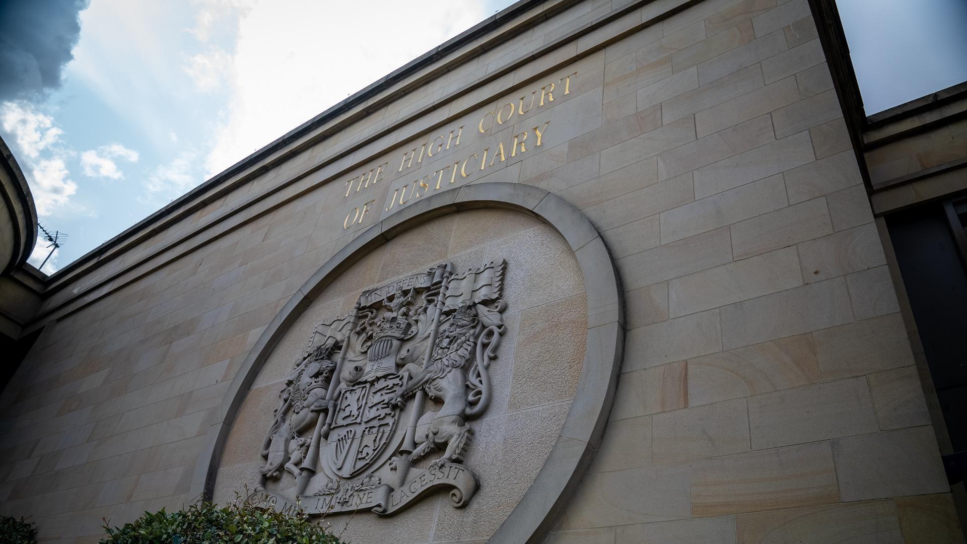 The outside of the High Court in Glasgow, with the judicial crest on the wall of the building