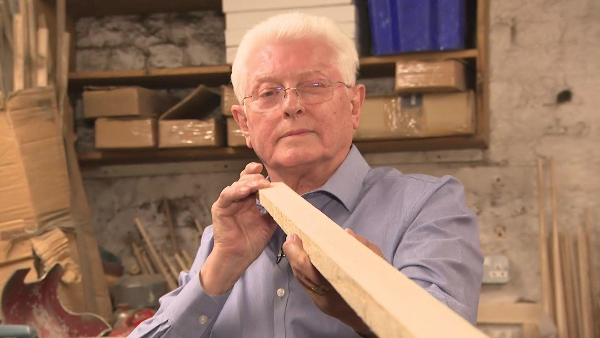 John Parris inspects a length of ash wood in his workshop at Parris Cues in South East London