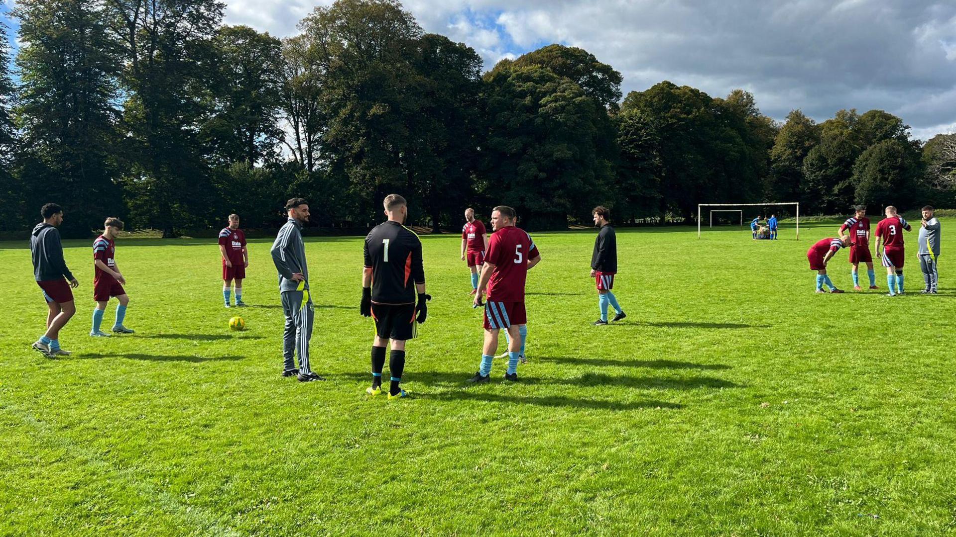 Players from Avenue Hotspur are seen talking amongst themselves on the pitch before the game