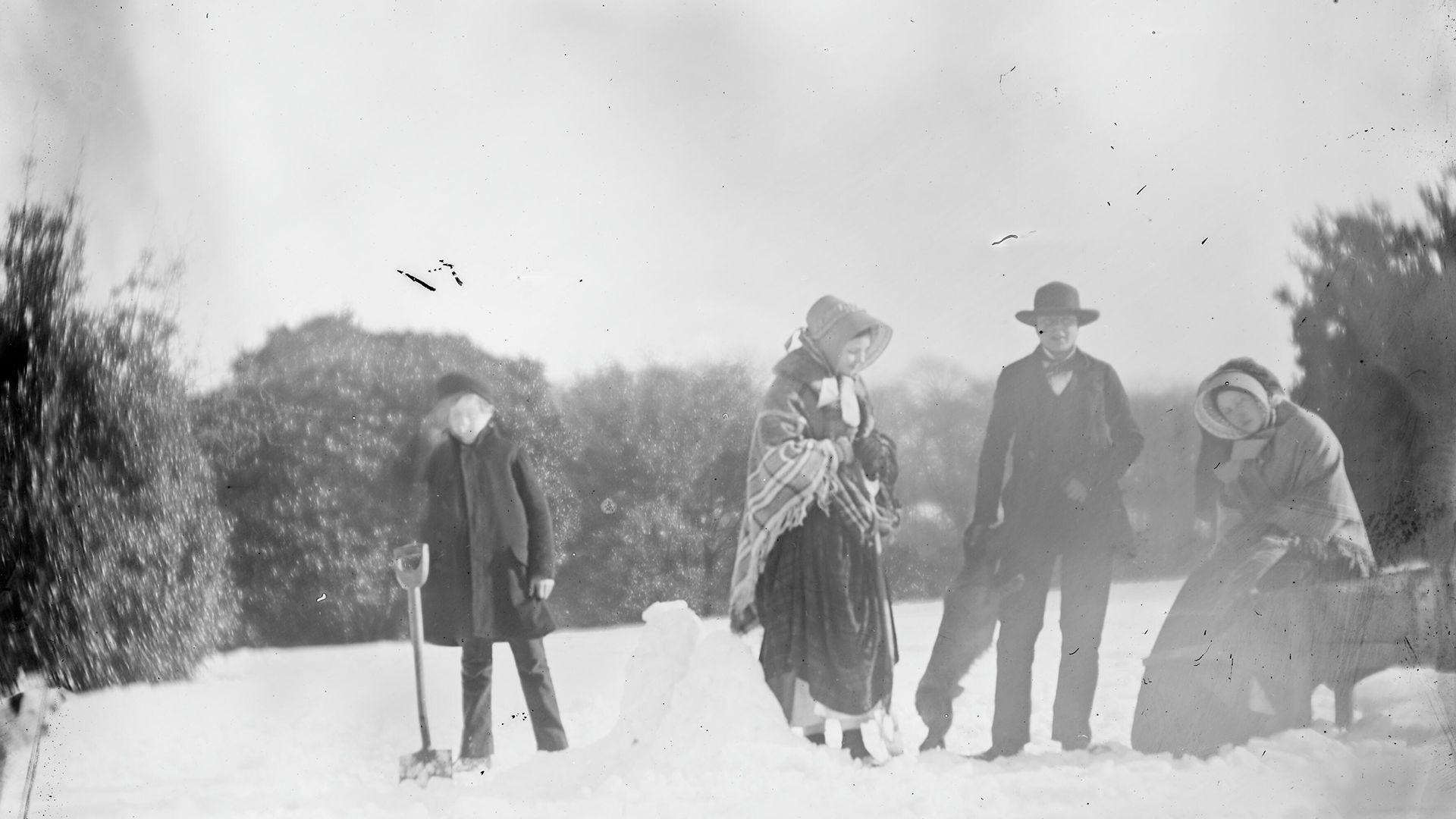 Hen lun du a gwyn o blentyn a phobl yn gwneud dyn eira