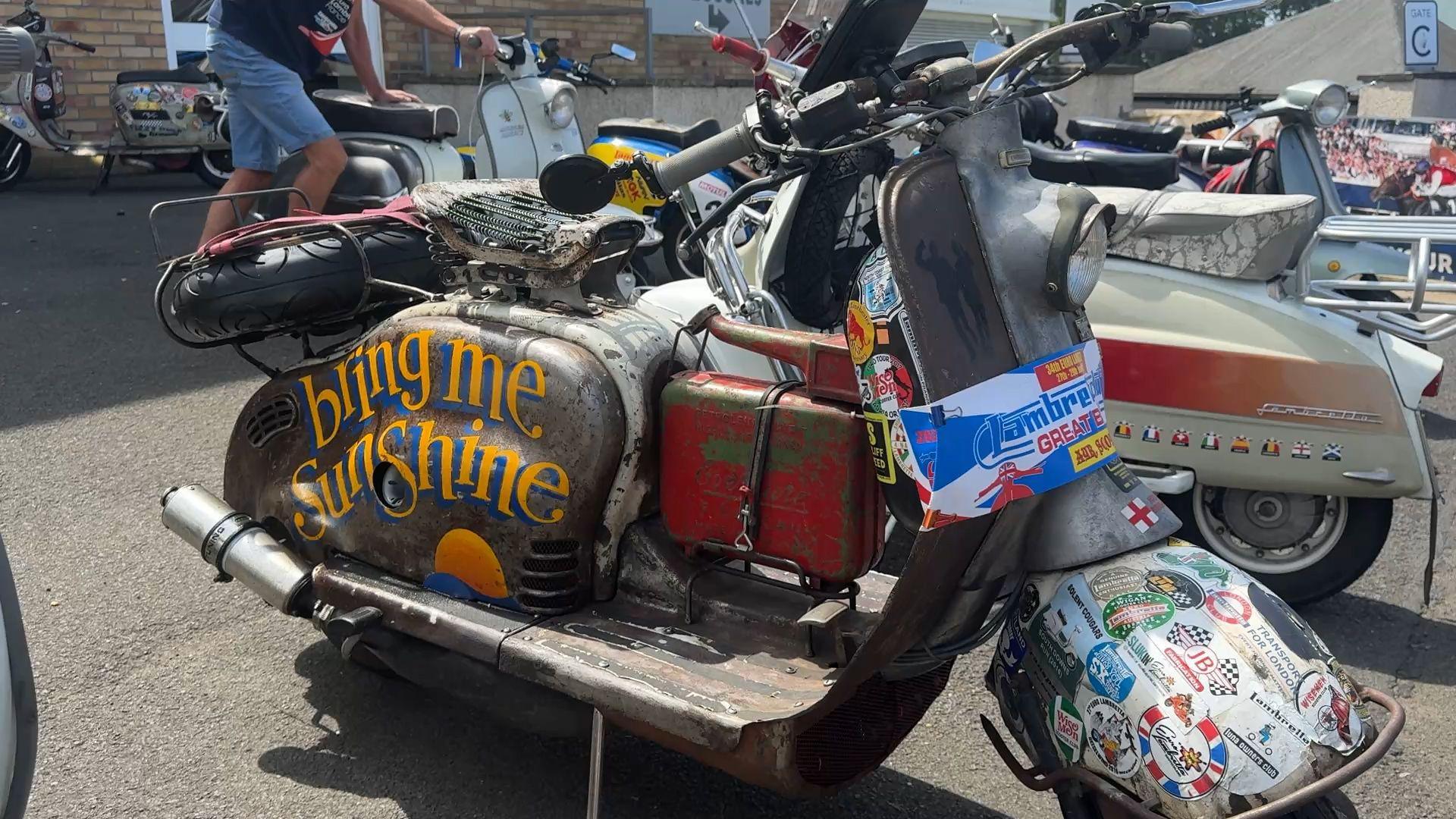 a colourful Lambretta has Bring Me Sunshine painted on the side