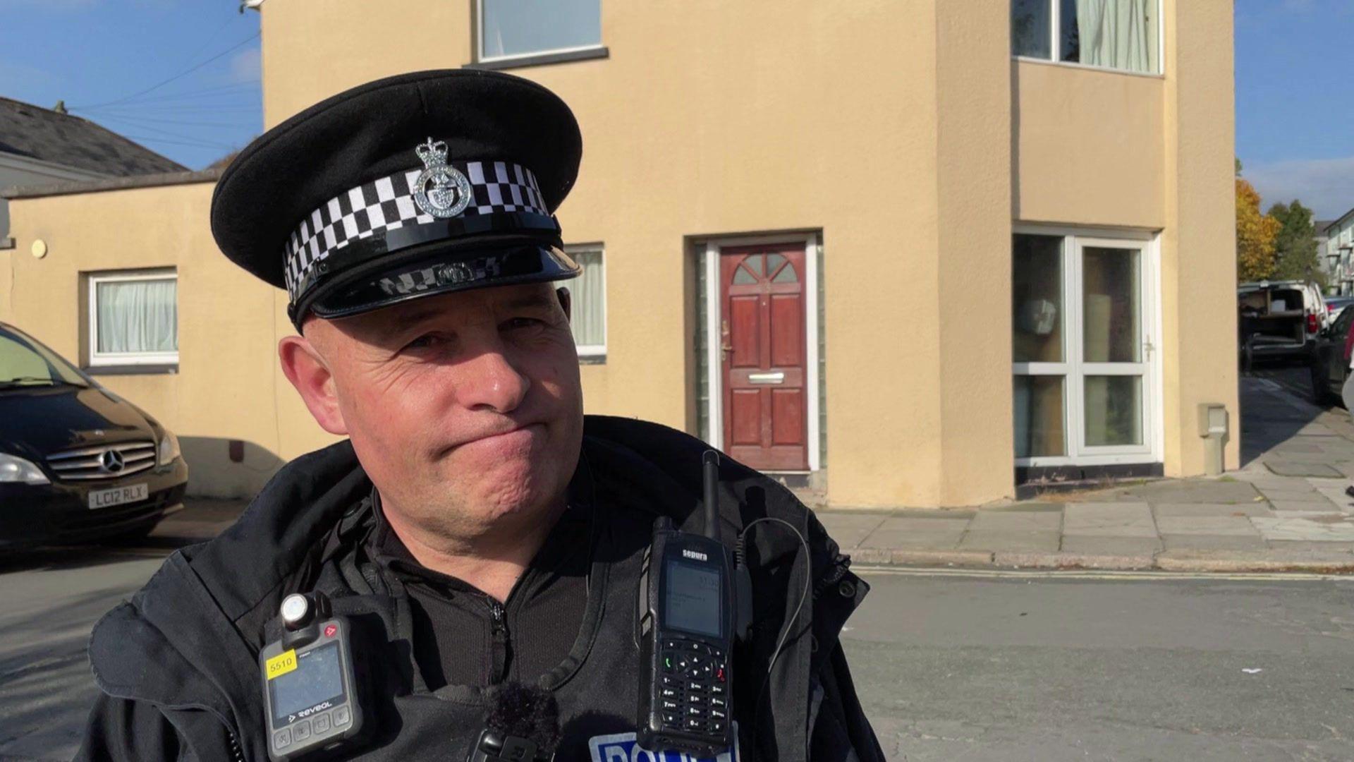 Sgt Steve Dykes is pictured near to the scene in Plymouth. He is smiling, wearing his police uniform and hat.