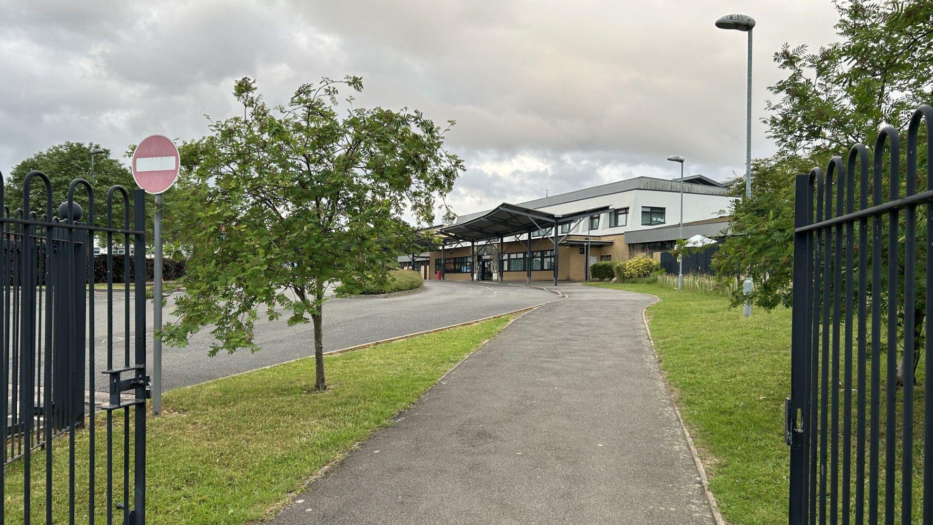 Forest Oak and Merstone schools. We see the path leading up to the schools from behind a gate.