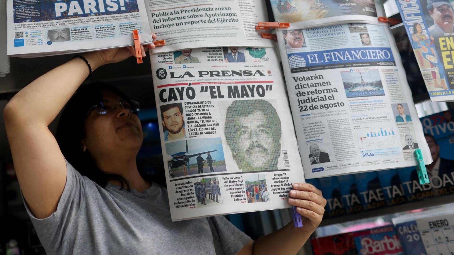 A newspaper seller arranges newspapers reporting the El Paso, Texas, U.S., arrest of Mexican drug lord Ismael "El Mayo" Zambada 