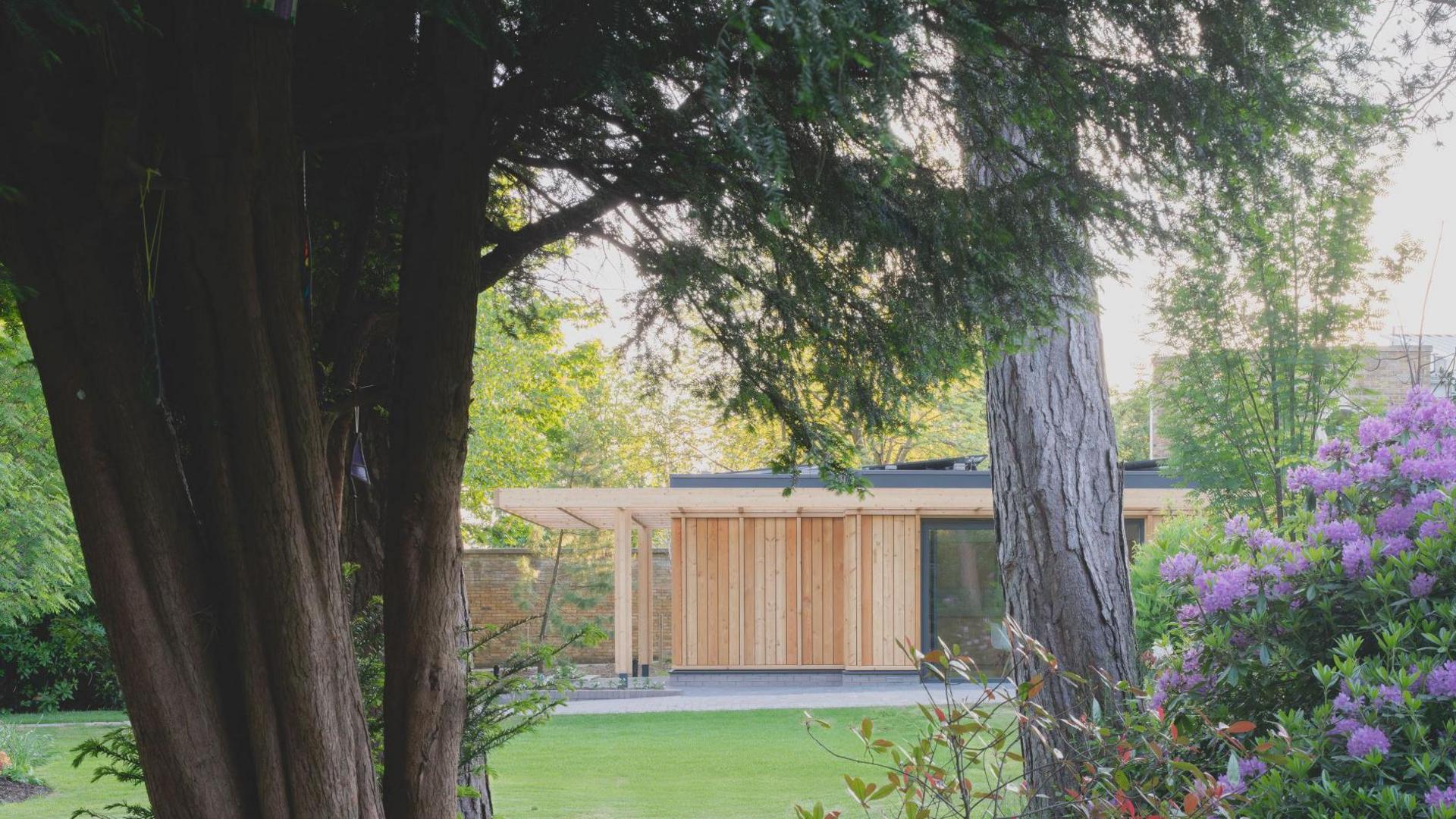 A picture, taken from a garden, shows a a timber building
