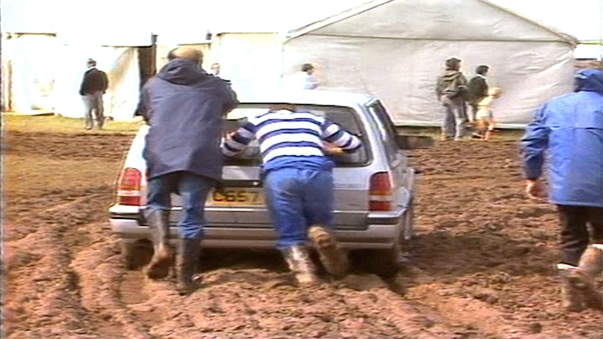 Dau ddyn yn gwthio car yn y mwd