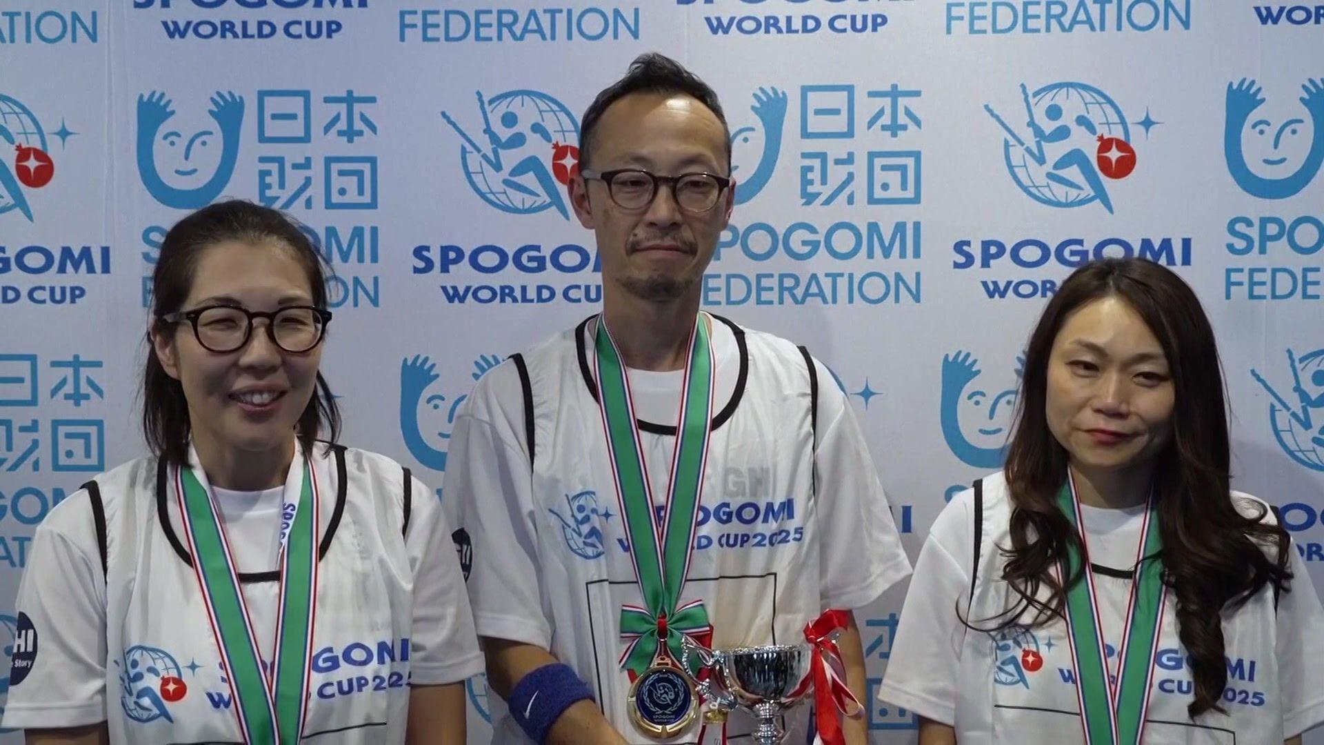 three member of Japan's litter picking team wearing medals on green ribbons