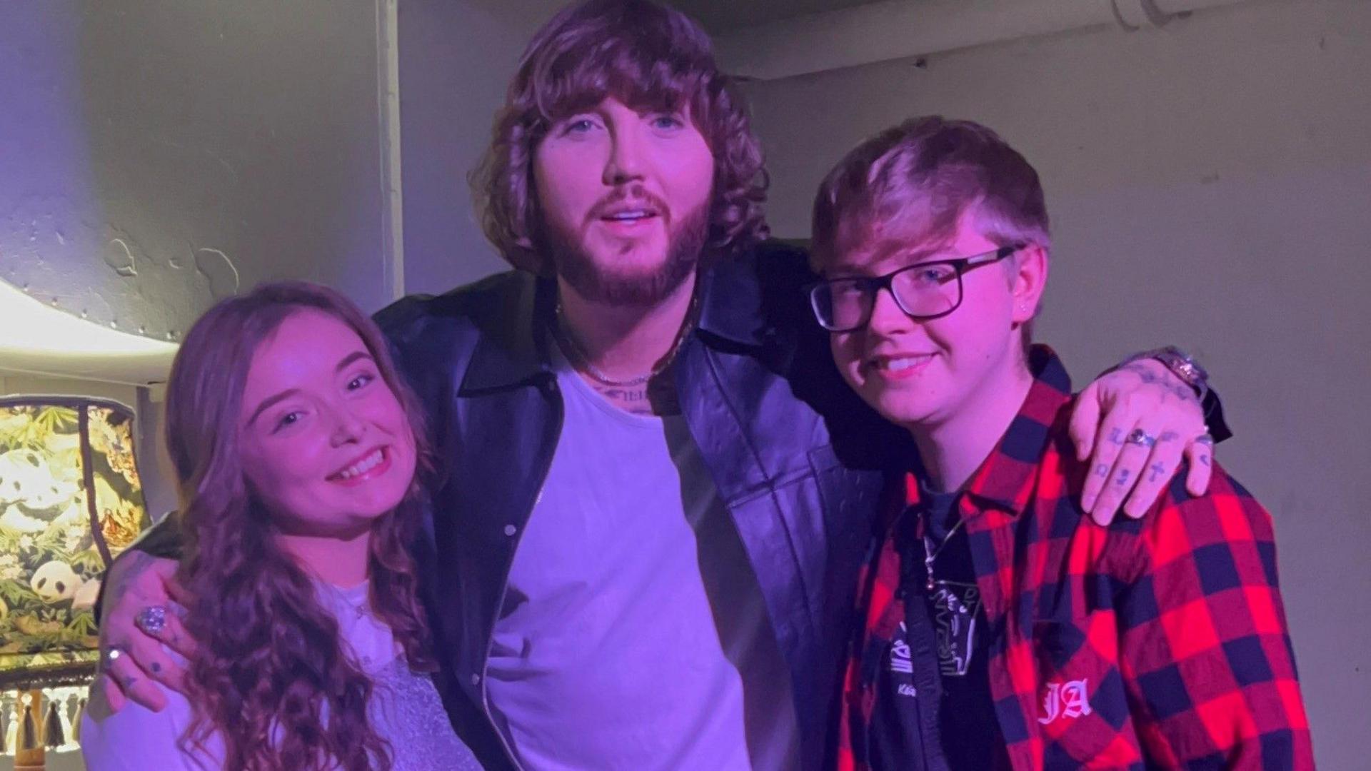 Milly and Lewis with their arms around James Arthur