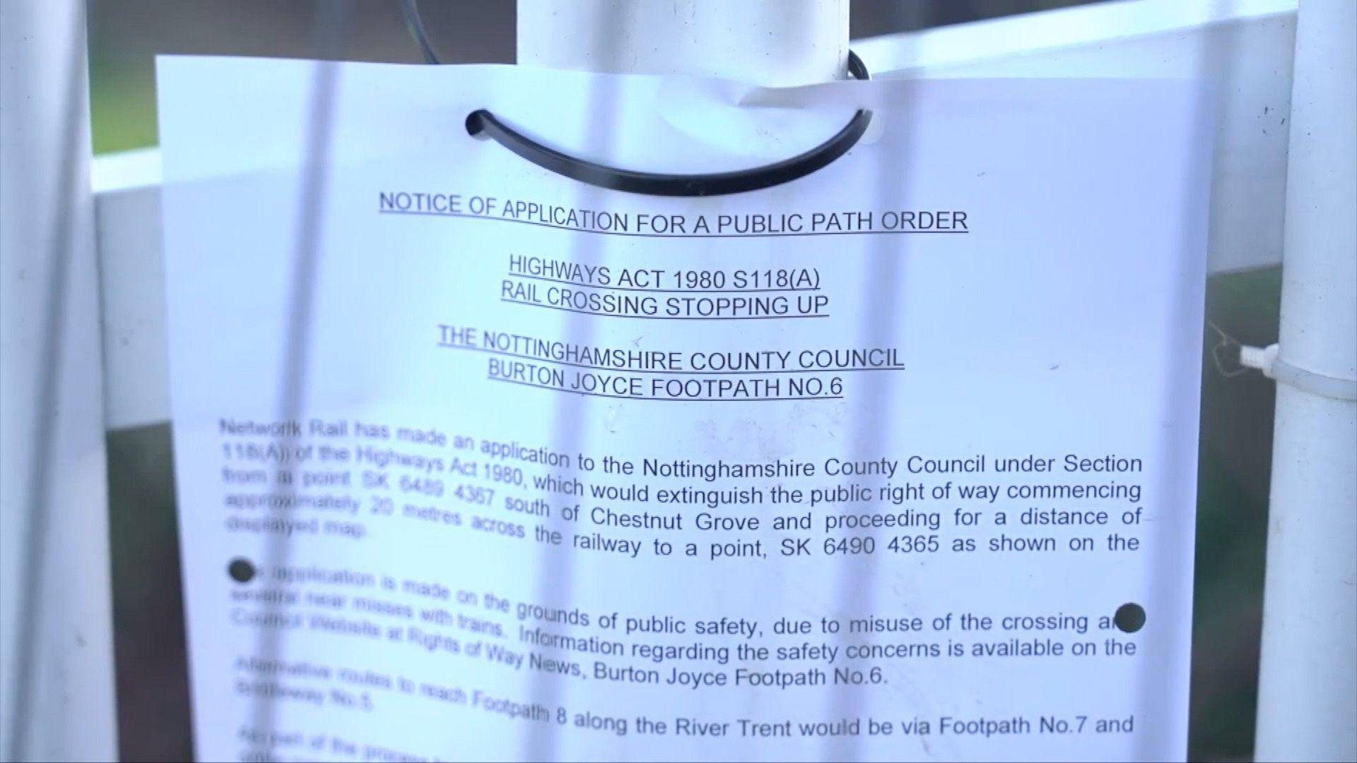 A white sheet of paper with black typed print attached to metal railings