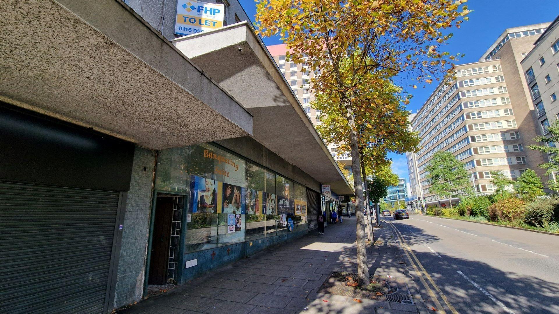 The exterior of the former Tales of Robin Hood attraction in Nottingham. Maid Marian Way, lined with trees, is seen outside of the building and towards the right of the image.