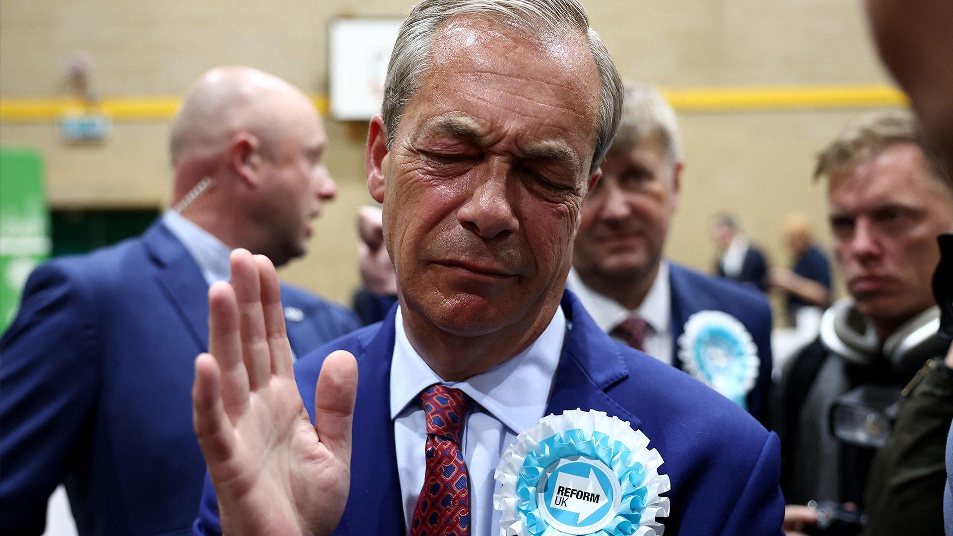 Nigel Farage shrugging and holding up a hand