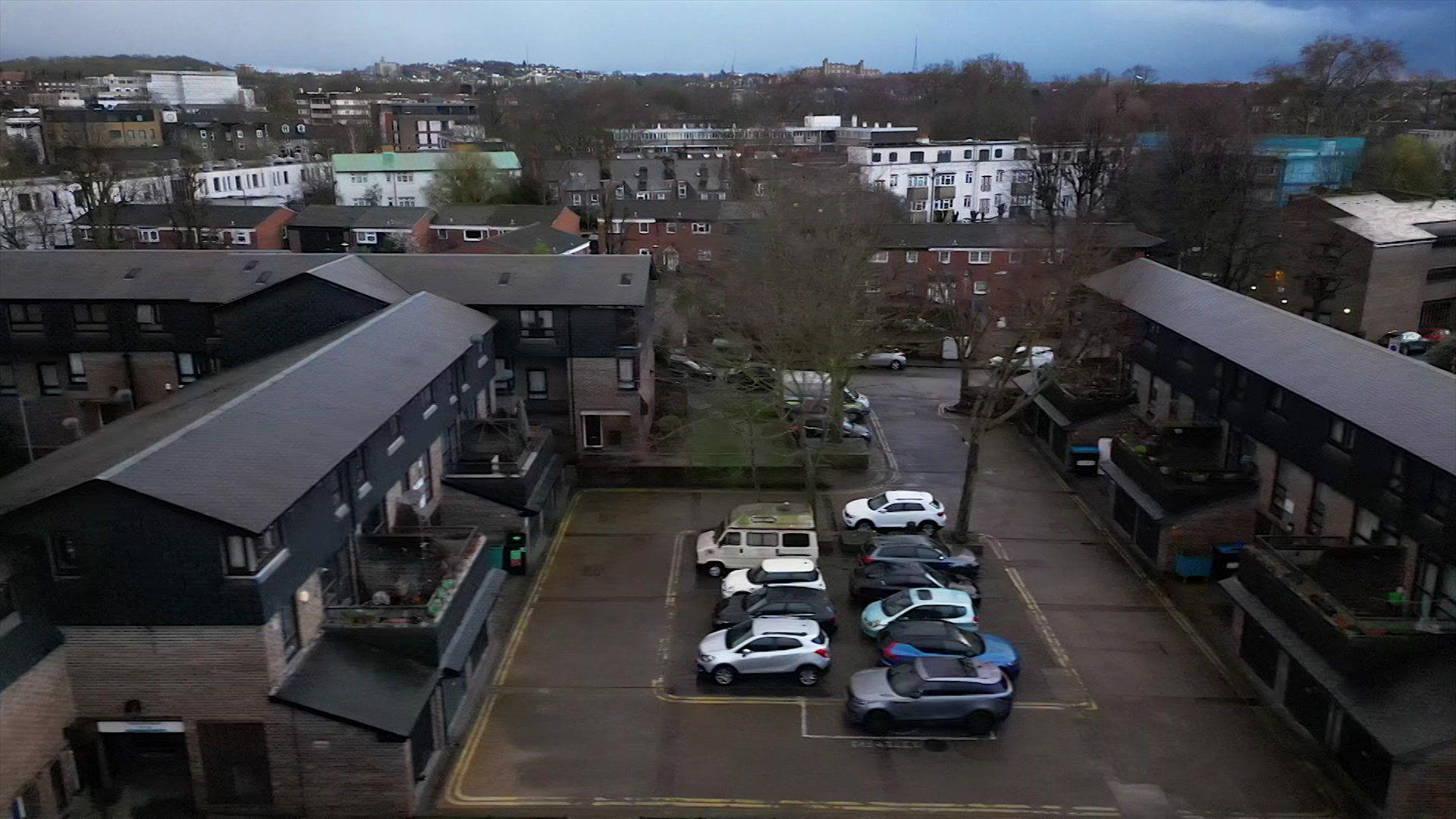 An aerial view of the Consort Estate in London. There is a car park below and terraced housing at either side of it.