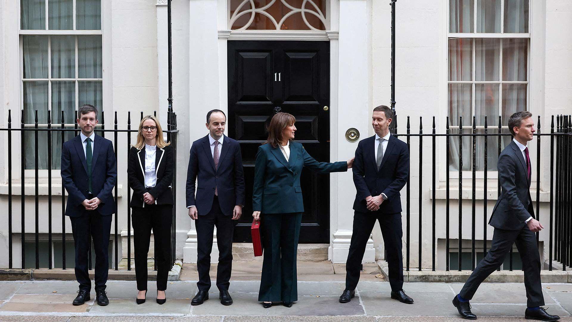 British Chancellor of the Exchequer Rachel Reeves holds the red budget box outside 11 Downing Street, as she stands with members of her team, in London, Britain, November 26, 2025.